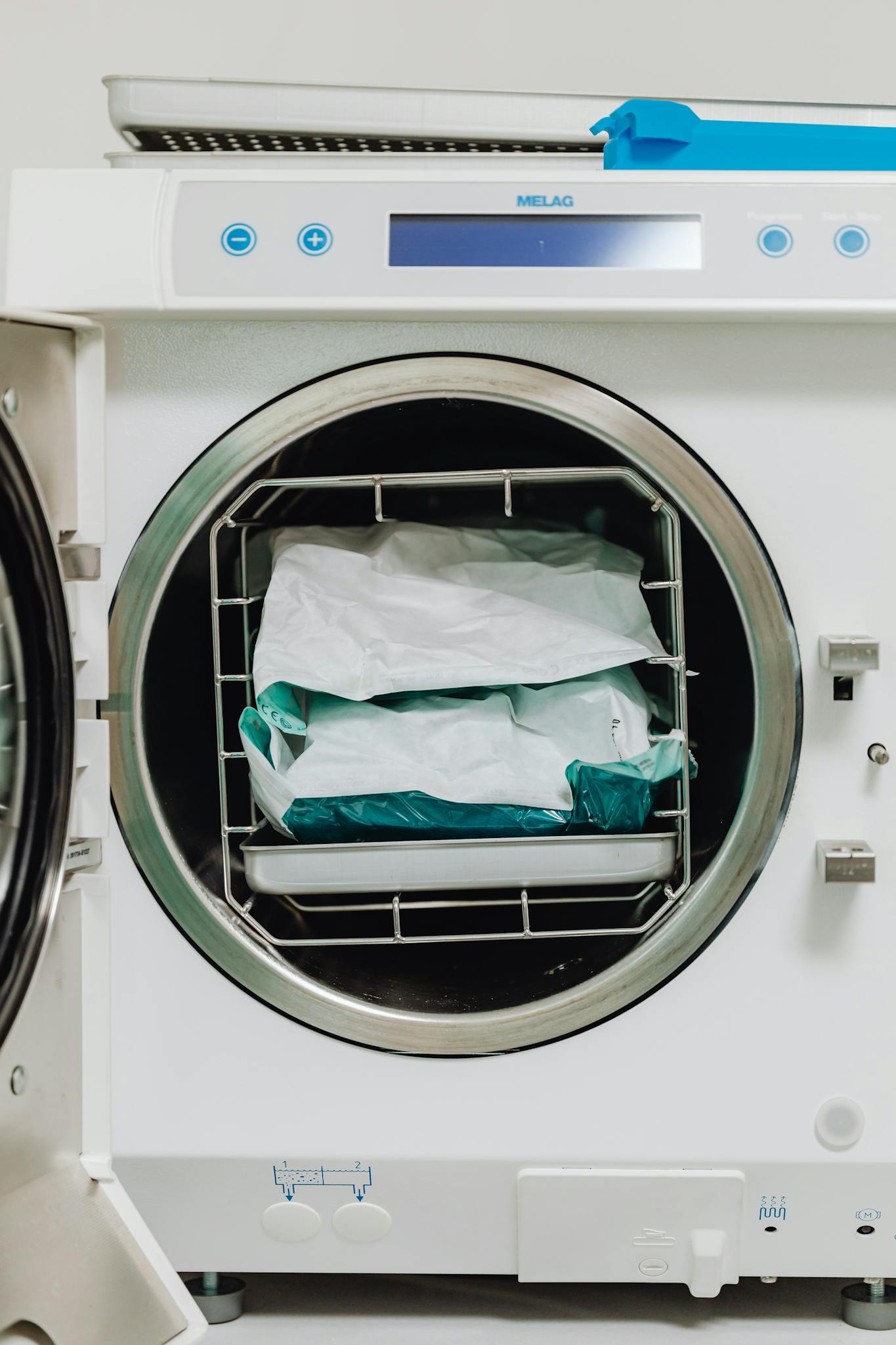 Medical sterilizer machine with sealed packages in a healthcare setting for hygiene processes.